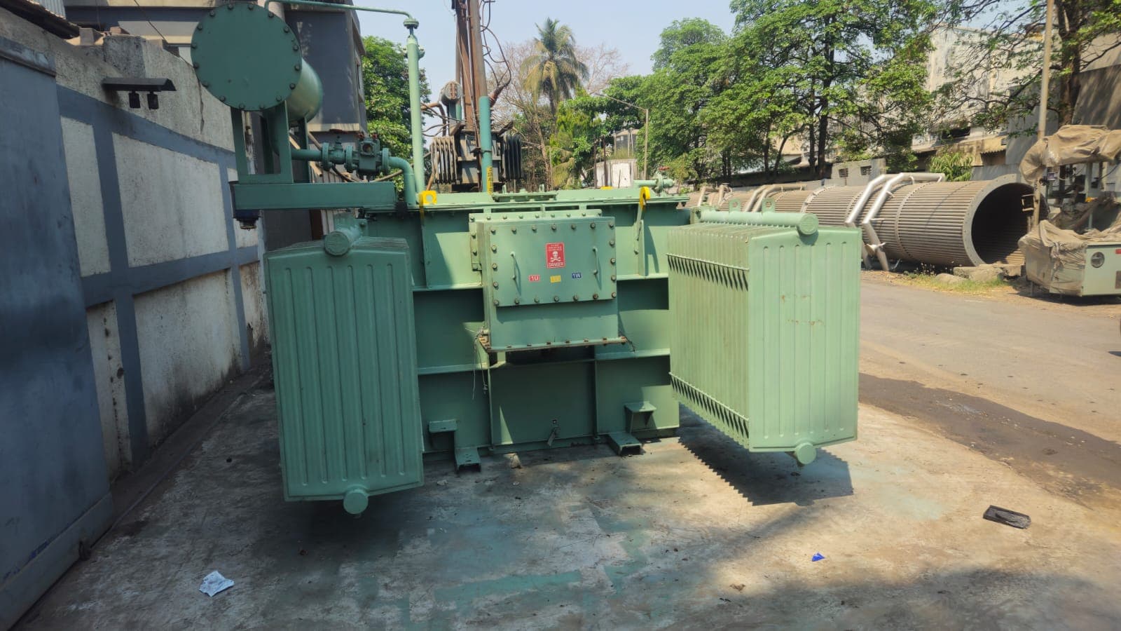 Green oil-immersed power transformer with detachable radiator banks and conservator, built by Tula Trans Electricals for 11 kV to 66 kV service